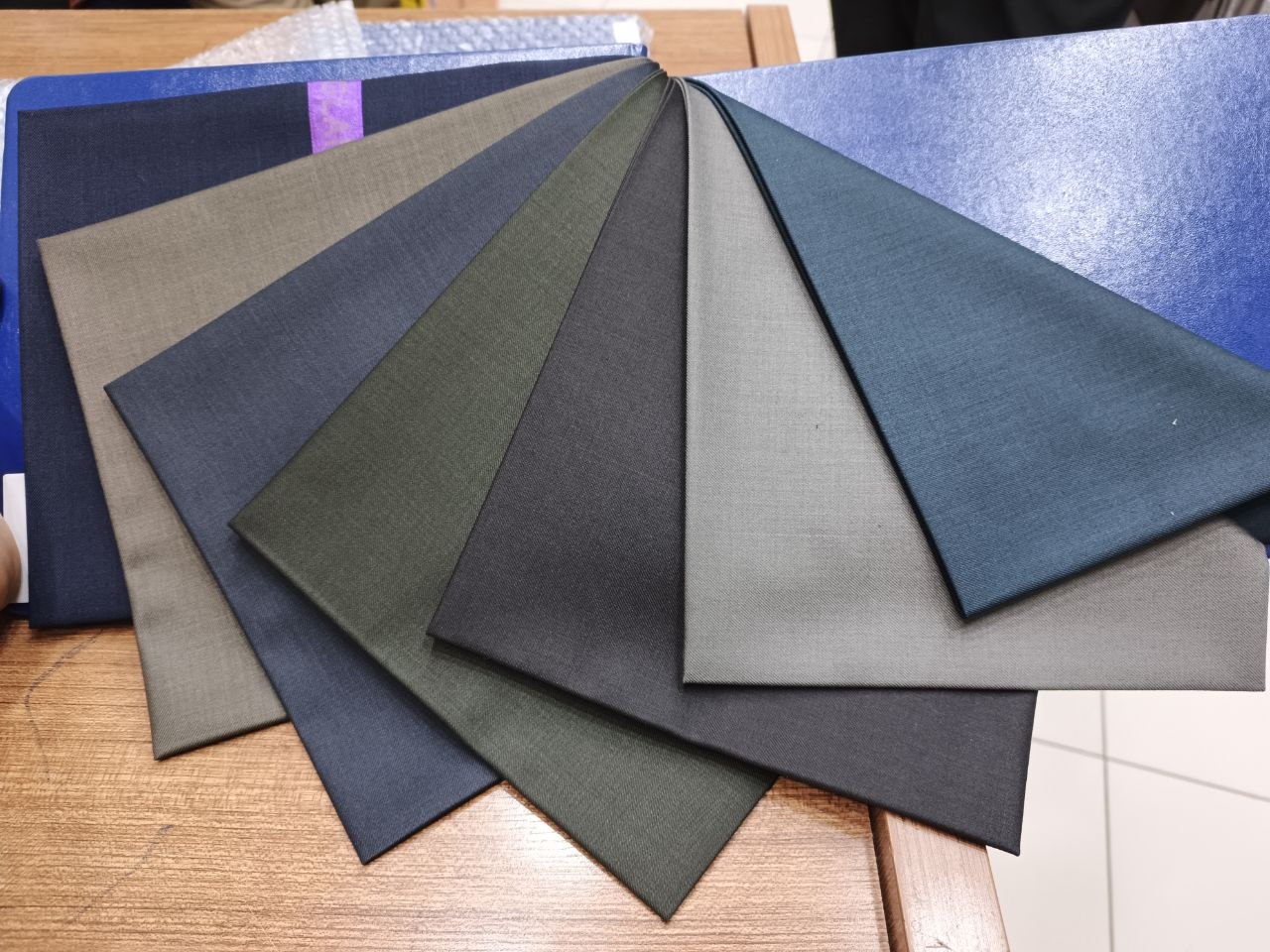 Fanned display of solid-color TR suiting fabric samples